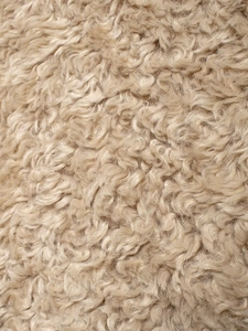 Close-up of soft beige fleece texture showing curly faux sheepskin fabric on the jacket