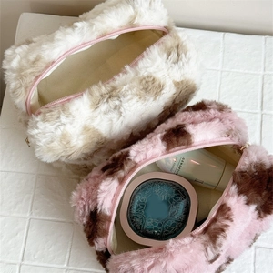 Detail view of plush leopard print makeup bags in beige and pink with soft fur texture