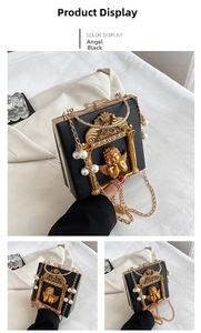 Detailed view of Angel Black baroque handbag with golden relief and crystal bow clasp