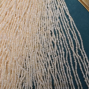 Macro view of tiny 2.5mm natural freshwater pearls on deep blue velvet background