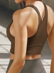 Detail view of seamless brown yoga sports bra back design on a fitness model