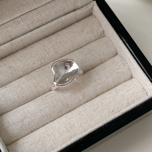 Detailed view of silver irregular fluid ring with polished finish on jewelry box