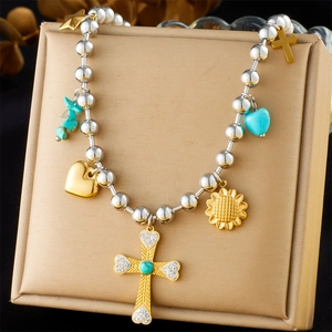 Detail der mehrlagigen Perlenkette mit Goldkreuz und Türkis-Herzanhängern für Damen