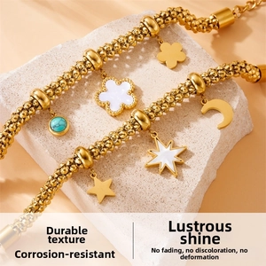 Detail of gold-plated chain bracelets with turquoise beads and flower moon charms