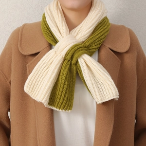Détail rapproché de l'écharpe en tricot bicolore beige et vert olive avec texture