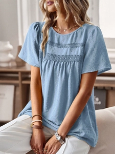 Detail of light blue short-sleeve top featuring white lace trim and textured dot fabric