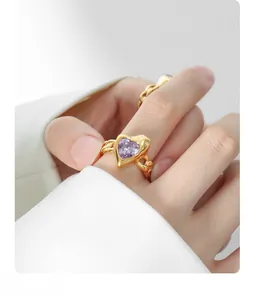 Detail view of heart-shaped purple zircon ring with gold-plated twisted band texture