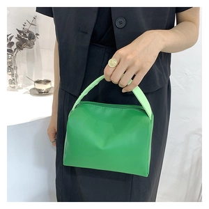 Close-up of a vibrant green PU leather small square handbag with a soft top handle