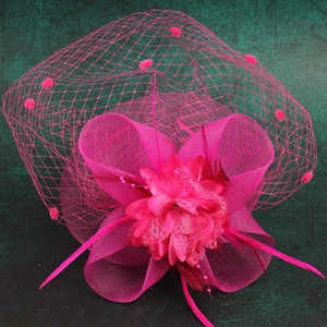Detail of rose red mesh fascinator hat with feathers and flower for weddings