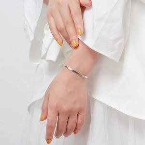 Minimalist S925 sterling silver flat snake chain bracelet worn on a woman's wrist