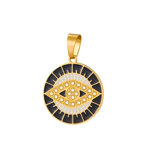 Macro shot of gold Evil Eye pendant with black enamel and sparkling crystal inlay