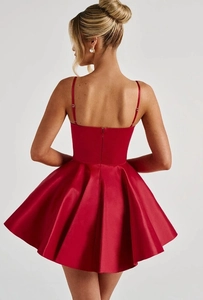 Detail of red satin cocktail dress featuring a pleated skirt and hidden back zipper