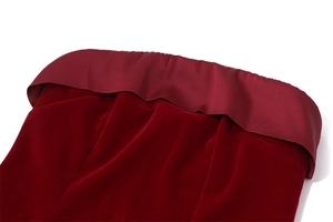Detalle de vestido de terciopelo burdeos con ribete de raso elegante y textura fina