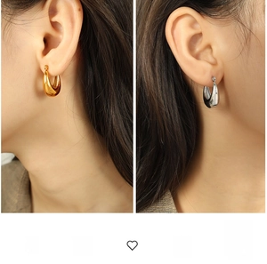 Close-up of thick gold and silver hollow hoop earrings in a glossy polished finish