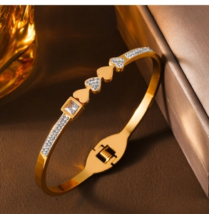Makro-Detail des goldenen Herzarmreifs mit Kristall-Pavé und quadratischem Edelstein