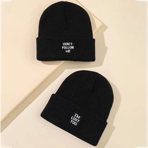Détail de bonnets en maille noire avec texte brodé blanc Don't Follow Me élégant