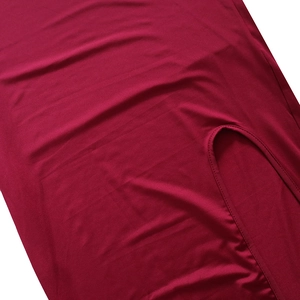 Detailed close-up showing burgundy fabric texture and split hem stitching of the dress