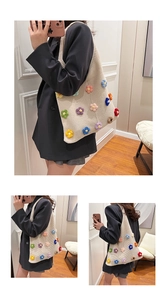 Detail view of cream knitted tote bag featuring colorful 3D crochet floral patterns