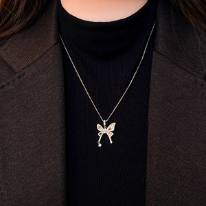 Elegant gold butterfly pendant necklace with colorful zircons and tassel on a model