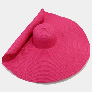 Dettaglio cappello di paglia fucsia con tesa larga e materiale intrecciato pieghevole
