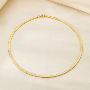 Detailed macro view of the 18k gold plated flat herringbone chain on beige silk fabric