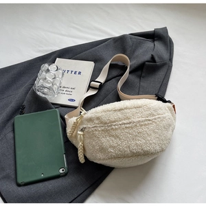 Close-up of creamy white lamb wool chest bag with adjustable strap and textured fabric detail