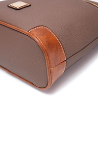Detailed close-up of brown pebble grain leather texture and stitching on the crossbody bag