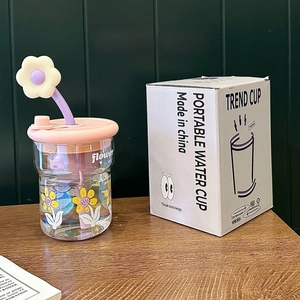Détail d'un gobelet en verre portable avec motif floral, couvercle et emballage cadeau