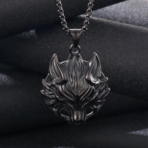 Detailed macro shot of a black stainless steel wolf head pendant with box chain