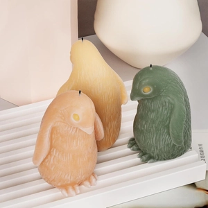 Detailansicht von 3D-Pinguin-Duftkerzen mit Federtextur auf einem Wellentablett