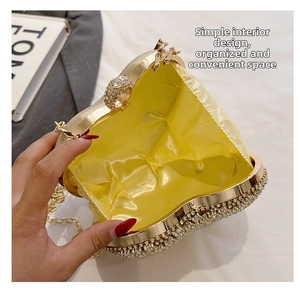 Detail view of heart-shaped evening clutch bag with gold lining and metal chain