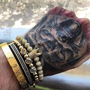 Men's crown bead and Roman numeral gold bracelet set with lion tattoo backdrop