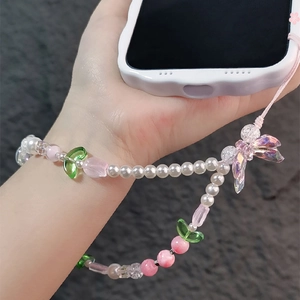 Detailed close-up of pink tulip beaded phone strap with peach and butterfly charms on wrist