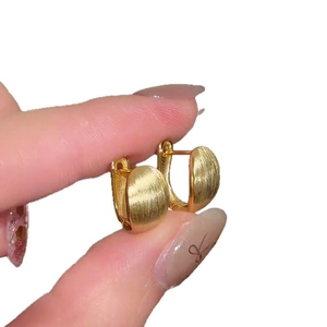 Minimalist 18k gold plated oval huggie earrings with a brushed metallic finish