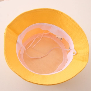 Detail view of cotton sun hat interior showing 100% cotton label and white windproof rope
