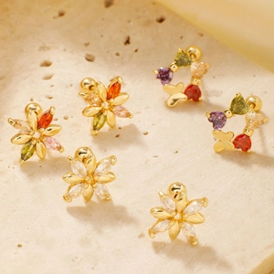 Boucles d'oreilles fleurs dorées avec zircons colorés sur pierre de travertin