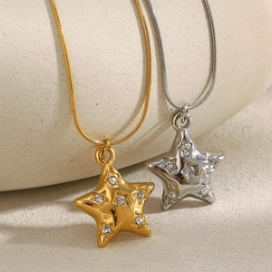 Detailed view of 18K gold and silver stainless steel star necklaces with crystals