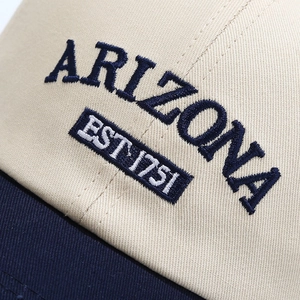 Close-up of beige and navy baseball cap with ARIZONA 1791 3D embroidery detail