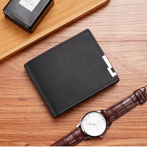 Close-up of black bifold leather wallet with L-shaped metal trim on wood background