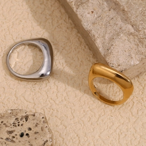 Macro detail of minimalist 18K gold and silver plated rectangular rings on stone base