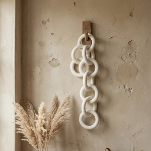 Minimalist ceramic chain wall decor hanging on rustic wall for wabi-sabi interior style