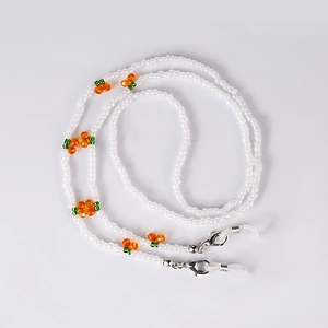 Close-up of white beaded chain with orange cherry accents and silver lobster clasps
