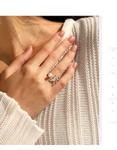 Detailed close-up of S925 silver mermaid tail ring with pearl on knit texture