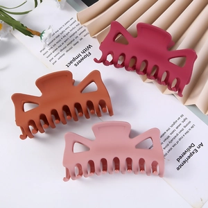 Detailed view of large rectangular hollow hair claws in red, caramel, and pink colors