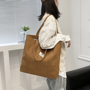 Brown corduroy large capacity tote bag shown on a model for daily commute and school