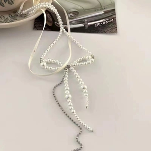 Elegant pearl bow necklace with silver metal chain and cream satin ribbon bow detail