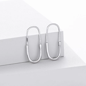 Detail showing high-polish S925 silver U-shape earrings on a white minimalist display