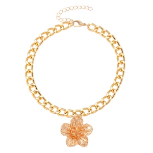 Macro shot of gold-plated Cuban chain necklace featuring a textured floral pendant