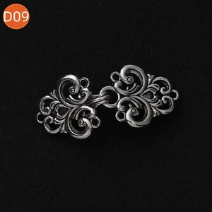 Détail macro du clip de cardigan argent antique avec motif floral évidé complexe