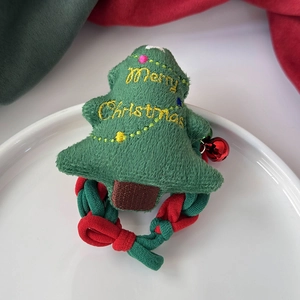 Détail d'un chouchou sapin de Noël en peluche avec broderie et petite cloche rouge